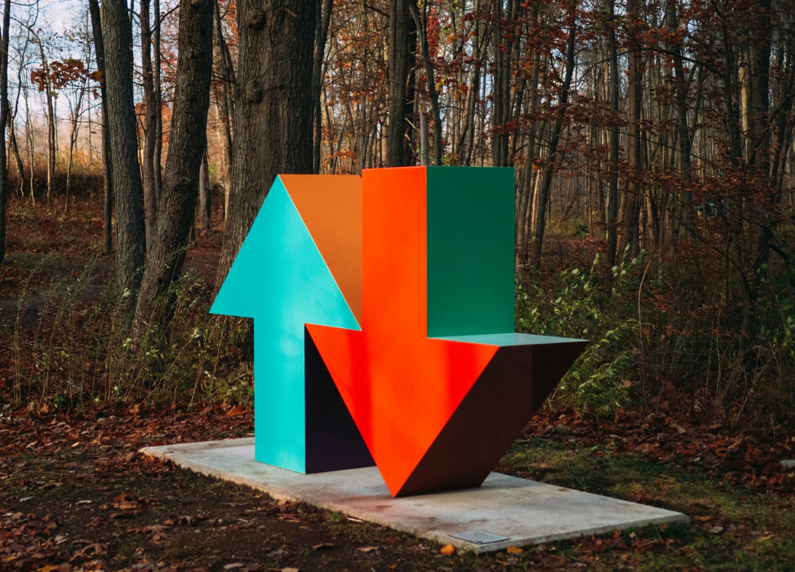 Eine Skulptur (Pfeile hoch und runter) im Wald - bunt.