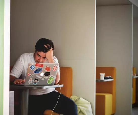 Student sitzt verzweifelt am Laptop während einer Prüfung