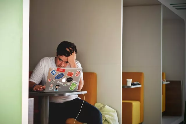 Student sitzt verzweifelt am Laptop während einer Prüfung