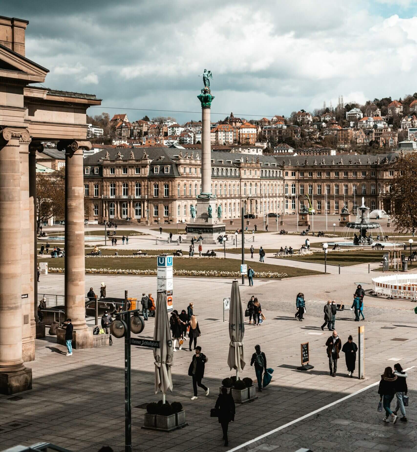 Eine Gruppe von Menschen, die um den Schlossplatz in Stuttgart herumlaufen.