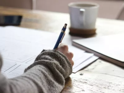 womans hand with pen on table