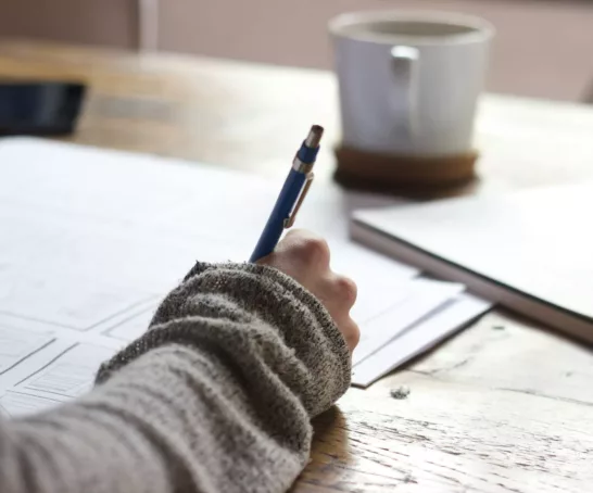 womans hand with pen on table