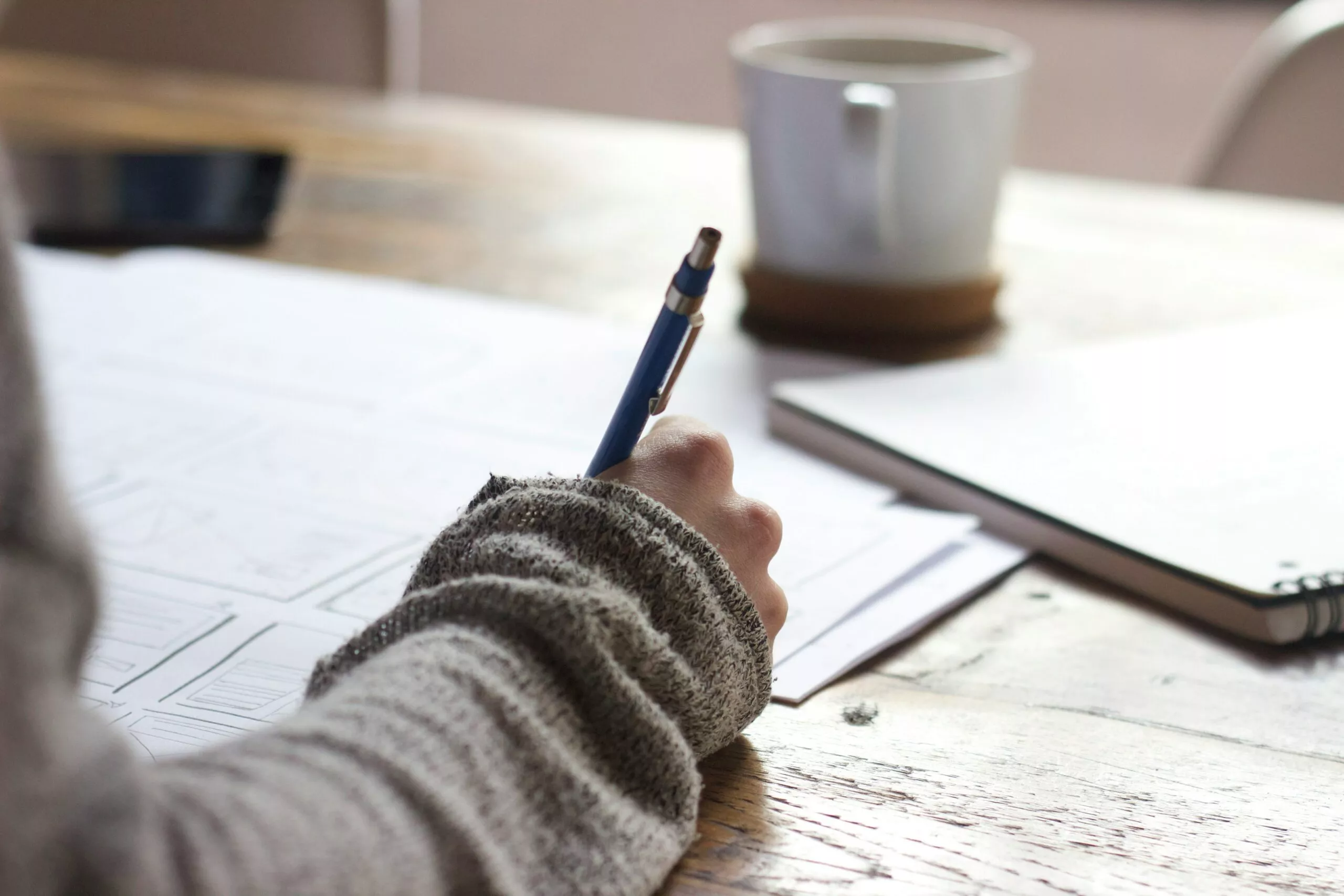 womans hand with pen on table